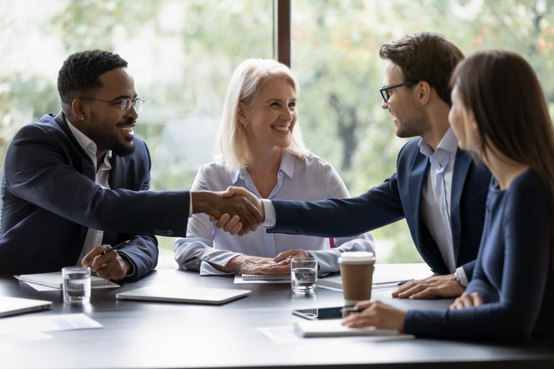 Business people shaking hands across a table